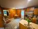 Spacious kitchen area with eat-in dining, stainless steel refrigerator, and wood paneled walls at 5141 Hiram Lithia Springs Rd, Powder Springs, GA 30127
