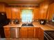 Kitchen featuring wooden cabinetry, stainless steel appliances, and a cozy ambiance with a sink and window at 5141 Hiram Lithia Springs Rd, Powder Springs, GA 30127