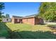 Large backyard featuring a brick home, green lawn, and mature trees at 120 Greenview Ter, Mcdonough, GA 30253