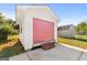 Detached garage with pink door and brick steps, adding a touch of color to the property at 120 Greenview Ter, Mcdonough, GA 30253