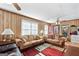 Cozy living room featuring wood paneling, plush sofas, and area rug at 120 Greenview Ter, Mcdonough, GA 30253