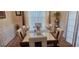 Dining room with a glass table, six white chairs, and natural lighting at 7314 Basalt Dr, Union City, GA 30291