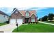 Charming two-story brick home featuring a well-manicured lawn, two-car garage, and classic architectural details at 7314 Basalt Dr, Union City, GA 30291