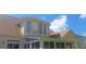 The rear exterior of home boasts a sunroom, a large lawn, and a backdrop of clear blue skies at 7314 Basalt Dr, Union City, GA 30291