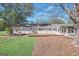 Back of home featuring a deck, well-maintained lawn, and mature trees providing shade at 308 Lee Thompson Rd, Moreland, GA 30259