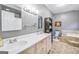 Well-lit bathroom featuring a double vanity, large mirror, and separate tub and toilet area at 308 Lee Thompson Rd, Moreland, GA 30259