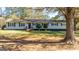 Exterior home view with mature trees, landscaping, and covered front porch entry at 308 Lee Thompson Rd, Moreland, GA 30259