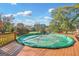 Covered outdoor pool on wooden deck surrounded by mature landscaping with clear skies at 308 Lee Thompson Rd, Moreland, GA 30259