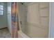 Bathtub with shower, curtain, and window. The shower features soap shelves and a chrome faucet at 2809 South Ola Rd, Locust Grove, GA 30248