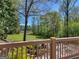 View of green lawn, trees and lake from deck with a decorative wooden railing at 2270 Emerald Dr, Jonesboro, GA 30236