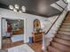 Foyer with hardwood stairs, chandelier, and a view into the office. A rug softens the hardwood floor at 2270 Emerald Dr, Jonesboro, GA 30236