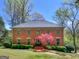 Beautiful two-story brick home featuring a manicured lawn, mature trees, and a classic American flag at 2270 Emerald Dr, Jonesboro, GA 30236