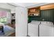 Laundry room featuring machines and storage with a glimpse of the dining room and exterior at 2270 Emerald Dr, Jonesboro, GA 30236