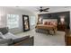 Spacious bedroom featuring a ceiling fan, accent wall, bench, and natural light from two windows at 2270 Emerald Dr, Jonesboro, GA 30236
