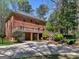 View of the brick house from the backyard, featuring a patio, wooden deck and a driveway at 2270 Emerald Dr, Jonesboro, GA 30236