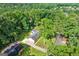 Lush tree canopy surrounds this home, providing ultimate privacy, with a long driveway and manicured front lawn at 3210 Roseheath Ln, Lithonia, GA 30038