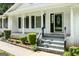 Charming covered front porch featuring white brick, black shutters, black front door and stairs at 3210 Roseheath Ln, Lithonia, GA 30038
