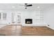 Open living room with hardwood floors, white brick fireplace, and French doors at 3210 Roseheath Ln, Lithonia, GA 30038