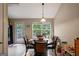 Bright dining area featuring a dark wood table, black chairs, and a view to the backyard through a large window at 8915 Tweeddale Dr, Winston, GA 30187