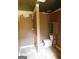 Bathroom with brown walls, toilet and wooden storage cabinet at 1306 Stonemont Rd, Auburn, GA 30011