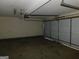 Empty garage with concrete floor and a partially open garage door at 1306 Stonemont Rd, Auburn, GA 30011