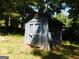 Rustic blue shed nestled among trees, ideal for storage or a workshop on the property at 1306 Stonemont Rd, Auburn, GA 30011