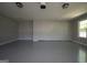 The empty garage features a gray floor and walls, a window, and two overhead lights at 2303 Sharon Se Ct, Conyers, GA 30013