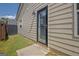 Exterior shot of the back door with a glass panel, set in light siding, and a small grass lawn at 395 Sylvan Loop, Fayetteville, GA 30214
