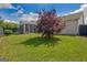 Backyard with a lush green lawn, a maple tree, wooden fence, and a screened-in porch in view at 395 Sylvan Loop, Fayetteville, GA 30214