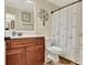 Well-lit bathroom with cherry wood vanity, decorative mirror, and butterfly-themed shower curtain at 395 Sylvan Loop, Fayetteville, GA 30214