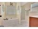 Bright bathroom with a soaking tub, enclosed glass shower, and neutral tile flooring, creating a serene spa-like atmosphere at 395 Sylvan Loop, Fayetteville, GA 30214