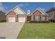 Charming brick home with a well-manicured lawn, two-car garage, and welcoming entrance at 395 Sylvan Loop, Fayetteville, GA 30214