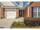 Close-up of a brick home with an inviting entrance, colorful flowers, and a two-car garage at 395 Sylvan Loop, Fayetteville, GA 30214