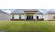 A well-manicured backyard, featuring a covered patio with outdoor seating, and lush green grass at 1225 Hibiscus Way, Mcdonough, GA 30253