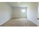 Neutral carpeted bedroom with a single window overlooking the backyard at 1225 Hibiscus Way, Mcdonough, GA 30253