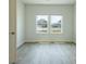 Empty bedroom with luxury vinyl plank flooring, white walls, and a view of the neighborhood through two windows at 1225 Hibiscus Way, Mcdonough, GA 30253