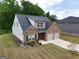 Aerial of brick home with siding, featuring a two-car garage and well-maintained lawn at 1225 Hibiscus Way, Mcdonough, GA 30253