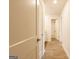 Hallway with wood-look flooring leading to a well-lit bathroom with a shower and bathtub at 1225 Hibiscus Way, Mcdonough, GA 30253