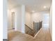 Upstairs hallway featuring neutral carpet, white walls, and black iron railing overlooking the staircase below at 1225 Hibiscus Way, Mcdonough, GA 30253