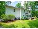 A lush green backyard is overlooked by a white two-story house and trees at 97 Coral Dr, Whitesburg, GA 30185