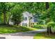 Beautiful home surrounded by mature trees and lush greenery, featuring a well-manicured lawn and driveway at 97 Coral Dr, Whitesburg, GA 30185