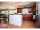 Spacious kitchen featuring an island, dark wood cabinetry, and a seamless flow into the adjacent living areas at 97 Coral Dr, Whitesburg, GA 30185