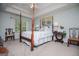 Spacious main bedroom with four-poster bed, decorative art, and a large window with backyard views at 97 Coral Dr, Whitesburg, GA 30185