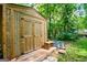 A wooden shed in a lush green backyard is a perfect place for storage at 97 Coral Dr, Whitesburg, GA 30185