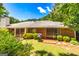Back exterior featuring a brick facade, patio, and lush landscaping at 105 Lake Forest Drive, Peachtree City, GA 30269