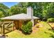 Back exterior featuring a brick facade, wooden privacy fence, patio, and lush landscaping at 105 Lake Forest Drive, Peachtree City, GA 30269