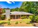 Back exterior featuring a brick facade, patio, and lush landscaping at 105 Lake Forest Drive, Peachtree City, GA 30269