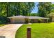 Charming brick ranch home with a well-manicured lawn, a two-car garage and a long driveway at 105 Lake Forest Drive, Peachtree City, GA 30269