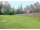 Spacious, grassy backyard featuring a wood fence and mature trees for privacy at 234 Thyme Leaf Way, Locust Grove, GA 30248