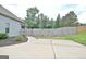 View of the backyard with concrete patio, privacy fence, and landscaping at 234 Thyme Leaf Way, Locust Grove, GA 30248